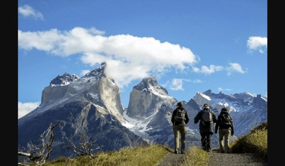 Hikers in Torres del Paine National Park with the background view of Los Cuernos (The Horns)