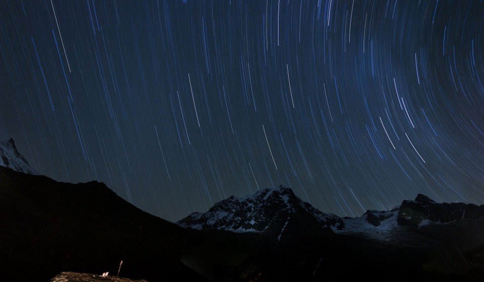 Star trails over Manaslu North (7157m) with a traditional stone and shingle house of Samagaon in the foreground.