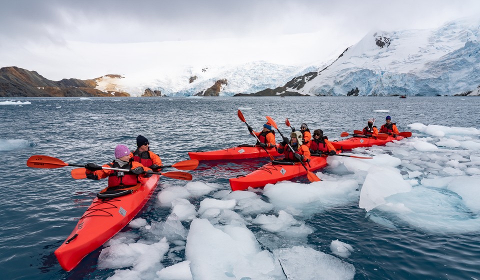 Customers kayaking in the Antarctic waters
